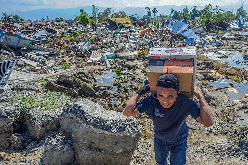 Man carrying supply, Palu, after Indonesia quake and tsunami