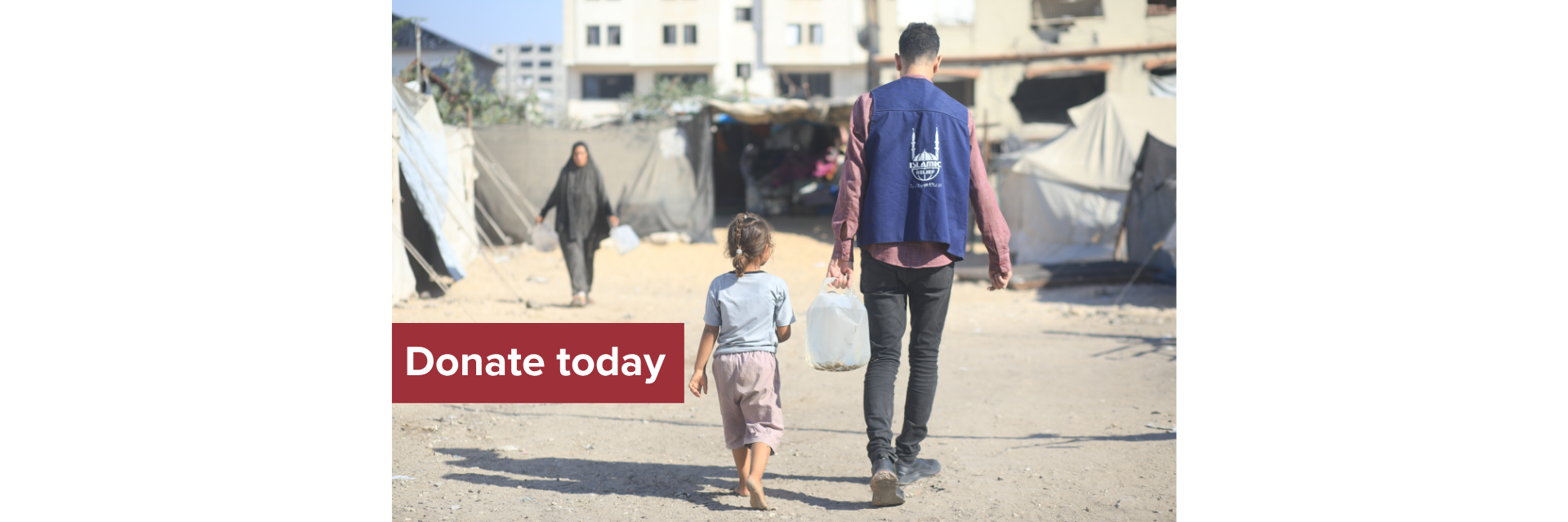 A humanitarian worker carries water for a child in a displacement camp.