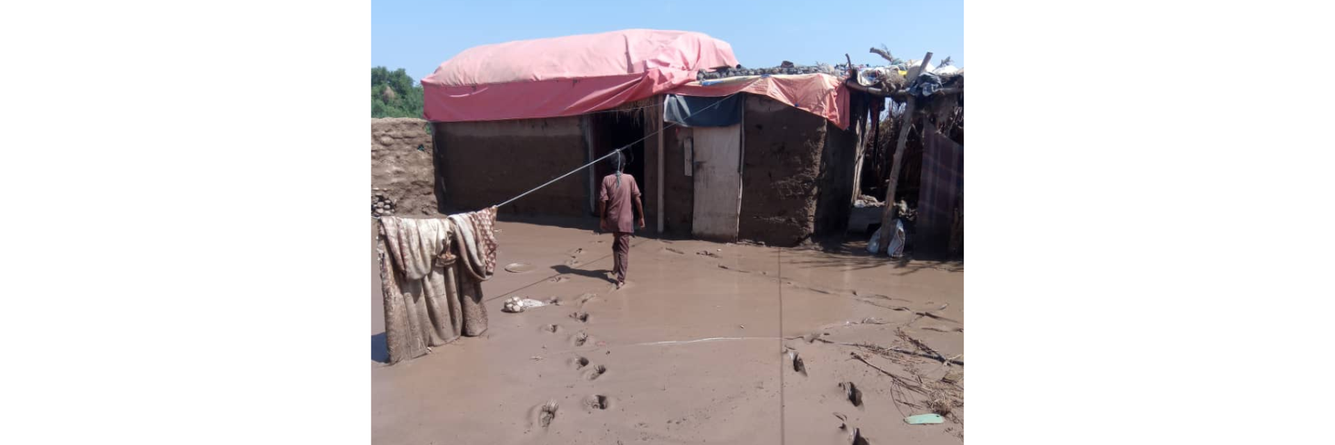 A man walking through mud to reach a shelter
