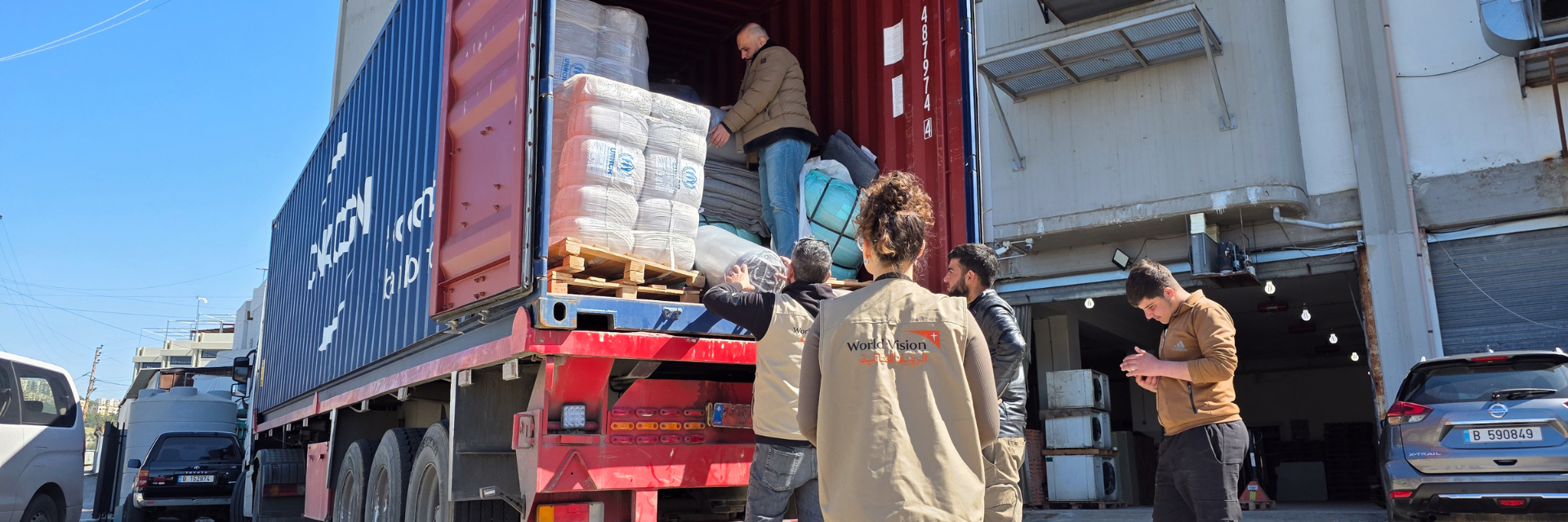 Humanitarian workers unload aid supplies from a truck in Lebanon