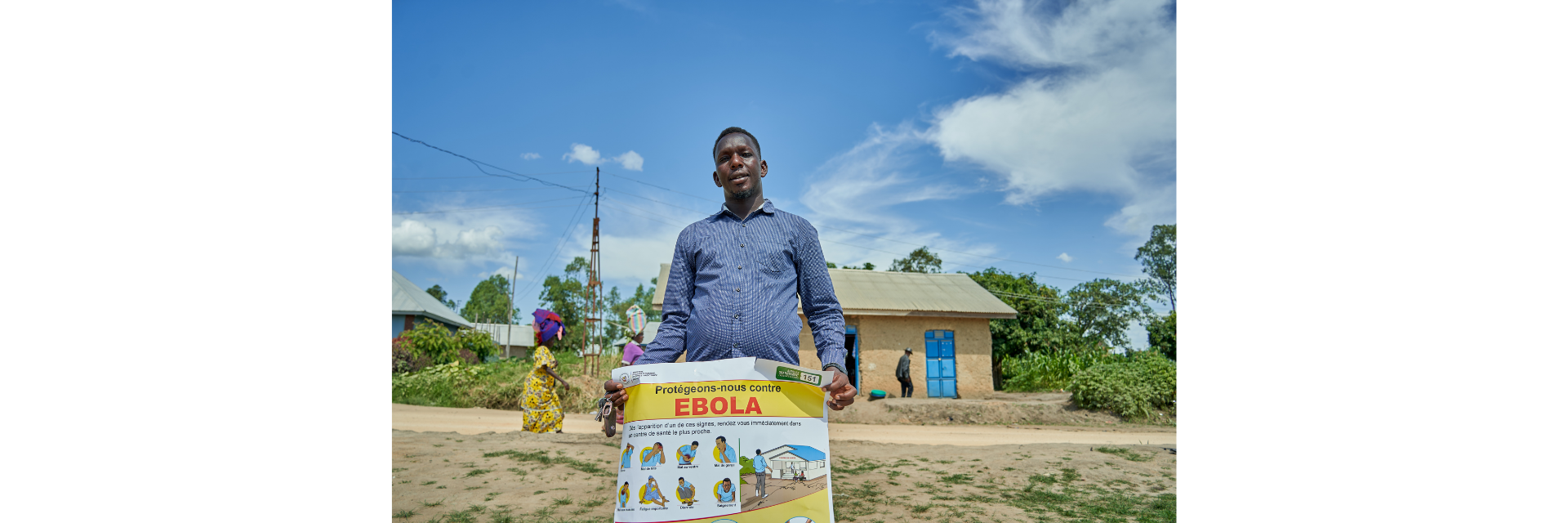 A man holding a poster that reads: "Let's protect ourselves against Ebola" in French.