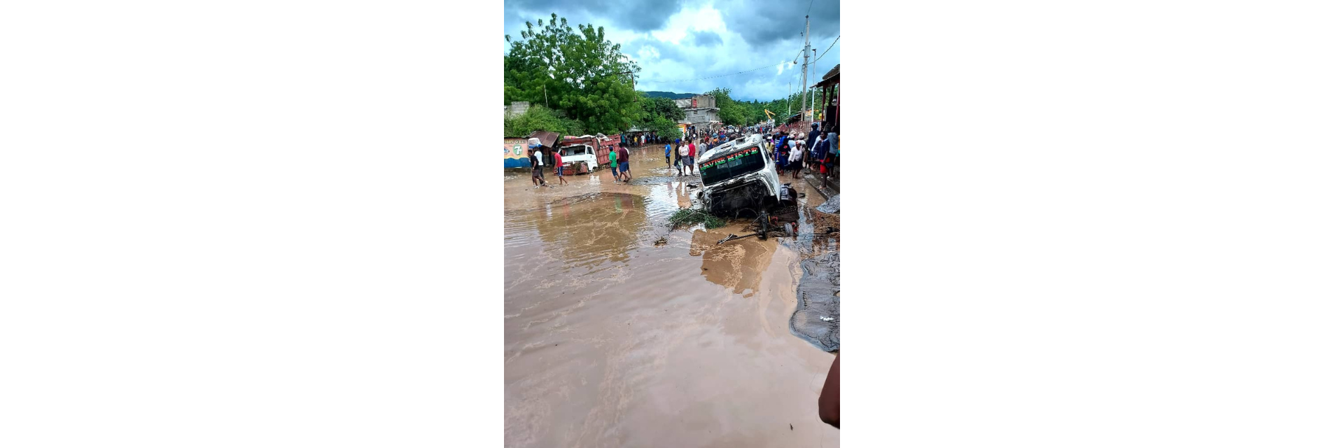 Trucks stuck in the mud on a crowded, flooded street