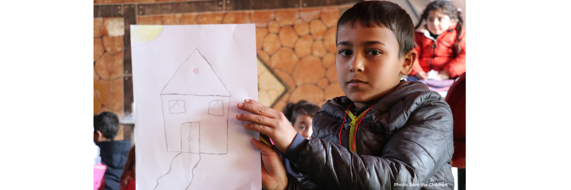 Basel, 6 years old, holding a drawing of his house