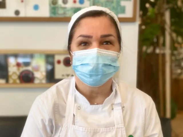 Woman with mask and an apron.