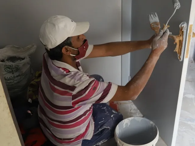 Man painting a door.