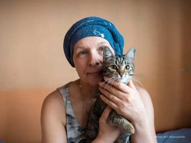 Larysa holds her cat Bella in the reception centre where her family is staying