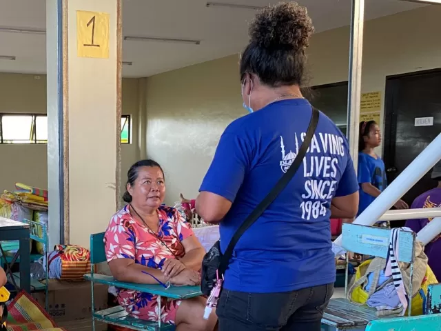 Hostess speaks with evacuee at reception centre