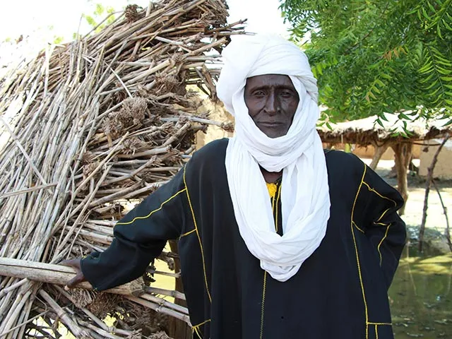 A man stands in front of his home