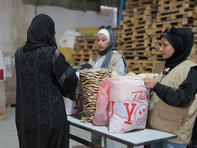 A woman receives a bag of clothing in Gaza