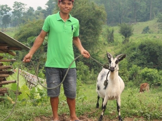 Vietnamese man stands with goat purchased with help of CARE Canada