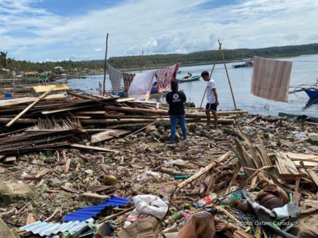 People standing in ruins in the Philippines