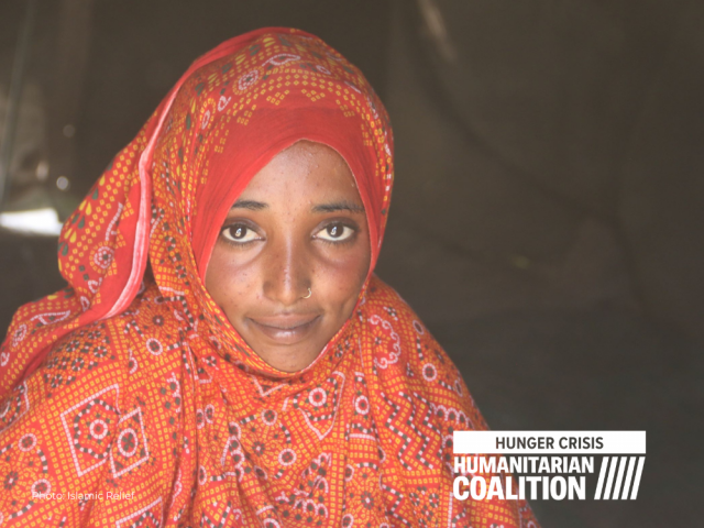 Young woman with orange veil looks at camera