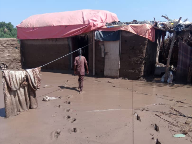 A man walking through mud to reach a shelter