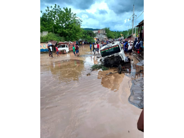 Trucks stuck in the mud on a crowded, flooded street