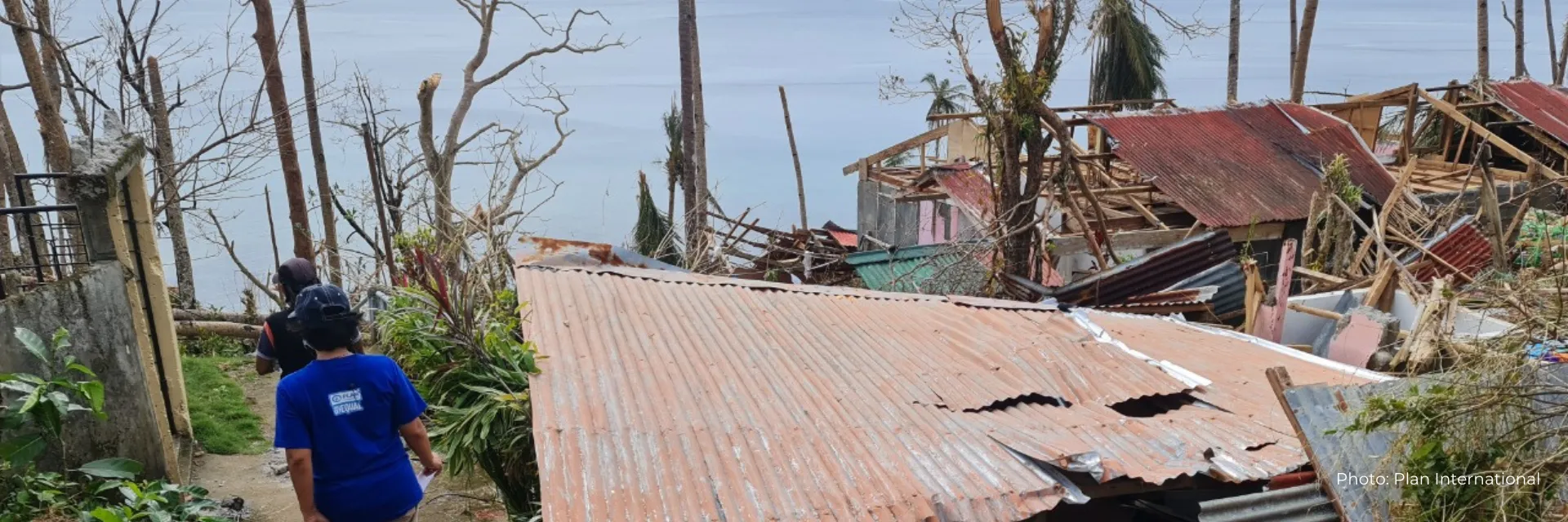 Two people survey the destruction left by Typhoon Rai