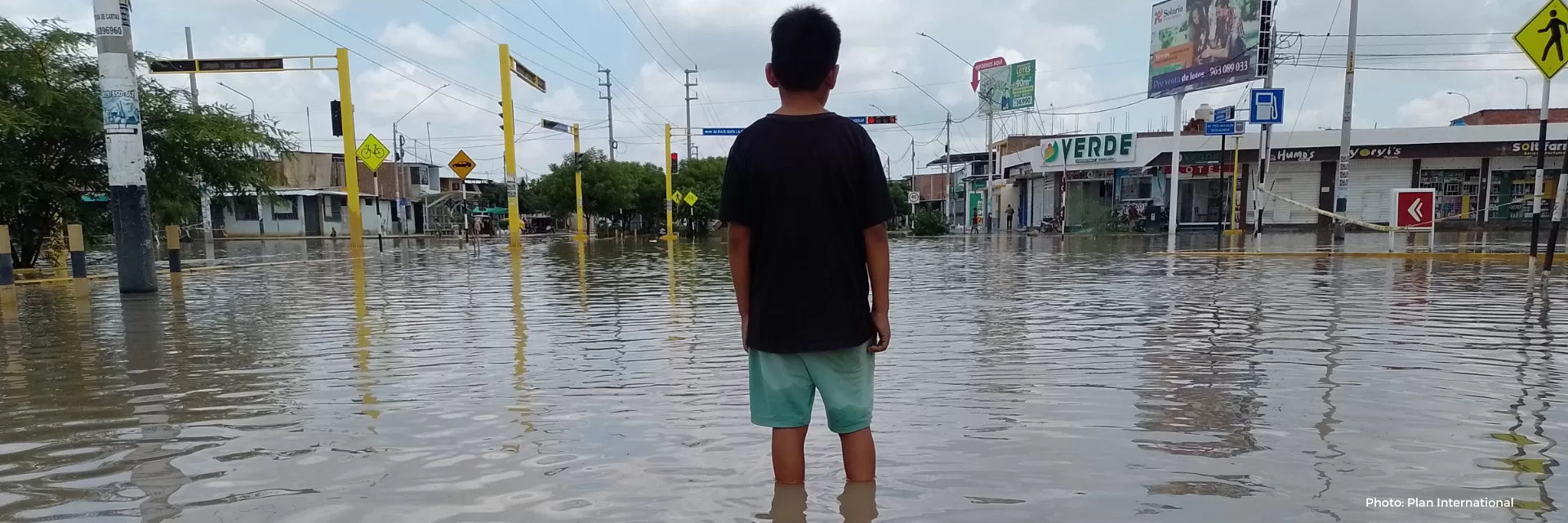 child standing in floods in Peru